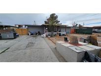 Modest single-story home featuring a covered porch and spacious front yard at 2125 Flower Ave, North Las Vegas, NV 89030