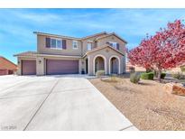 Two-story home featuring a large driveway, three-car garage and inviting arched entryway at 3809 Vincelli Ave, North Las Vegas, NV 89031