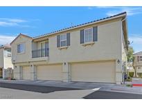 Three-story home with a three-car garage, charming balcony, and neutral stucco finish at 3920 Sweet Pine St # 102, Las Vegas, NV 89108