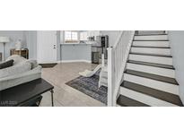 Inviting living area features tile flooring, light gray walls, and stairs to the second floor at 3920 Sweet Pine St # 102, Las Vegas, NV 89108