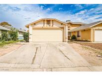 Beige single-story home featuring a two-car garage and a concrete driveway under a cloudy blue sky at 4438 Faberge Ave, Las Vegas, NV 89115