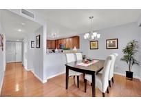 Charming dining room features a modern chandelier, hardwood floors, and comfortable seating for four at 7950 W Flamingo Rd # 1044, Las Vegas, NV 89147