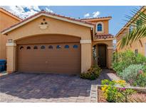 Charming single-Gathering home showcasing desert landscaping, a two-car garage and a quaint arched entryway at 8117 Discovery Point St, Las Vegas, NV 89139