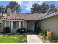 Charming front entrance features a tile roof, well-maintained landscaping and inviting walkway at 8641 Surtidor Dr, Las Vegas, NV 89117