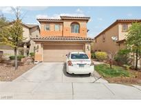 Two-story tan and orange home with a two car garage and tile roof and landscaping at 11620 Longhirst Hall Ln, Las Vegas, NV 89138