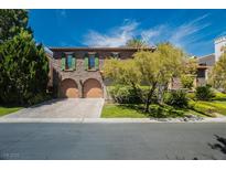 Charming two-story home featuring a brick driveway, two-car garage and beautiful landscaping at 12097 Oakland Hills Dr, Las Vegas, NV 89141