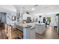 Bright kitchen featuring white cabinets, granite countertops, stainless steel appliances, and an island with breakfast bar at 2606 Crested Butte St, Henderson, NV 89052