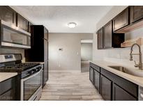 Updated kitchen featuring stainless steel appliances and modern cabinets with white countertops at 2641 Arrowhead St, North Las Vegas, NV 89030