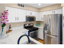 Bright kitchen features white cabinets, quartz countertops, and stainless steel appliances at 3123 Key Largo Dr # 101, Las Vegas, NV 89120
