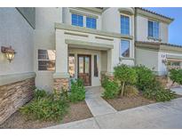 Inviting front entrance with a rustic wood door and beautiful stone accents, landscaped for curb appeal at 5337 Polizze Ave, Las Vegas, NV 89141