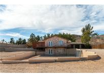 Two-story home with stone accents, a second story balcony, and desert landscaping at 9865 Penny Ln, Las Vegas, NV 89178