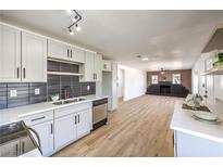 This open kitchen features stainless steel appliances, modern lighting, and a beautiful countertop at 1642 E St, Las Vegas, NV 89106