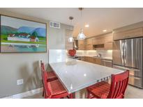 Bright kitchen features a breakfast bar with white countertops, red bar stools, and stainless steel appliances at 205 E Harmon Ave # 1007, Las Vegas, NV 89169