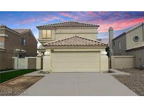 Two-story home featuring a beige exterior, two-car garage, and desert landscaping at 367 Lander Dr, Henderson, NV 89074