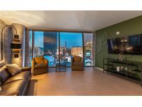 Modern living room with a leather sofa and expansive windows overlooking the Las Vegas skyline at 3722 Las Vegas Blvd # 1908, Las Vegas, NV 89158