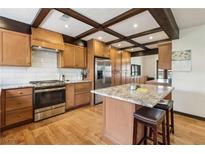 Well-lit kitchen features stainless steel appliances, a tiled backsplash, and hardwood flooring at 6712 Kittery Dr, Las Vegas, NV 89107