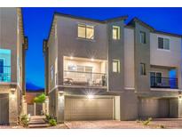 Modern two-story townhome featuring a private balcony and a two-car garage at twilight at 6821 Prairie Pearl St, Las Vegas, NV 89148