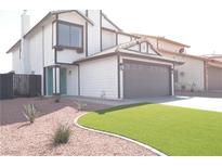 Inviting two-story home featuring a manicured lawn, a two-car garage, and a charming aqua-colored front door at 8101 Spur Ct, Las Vegas, NV 89145