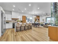 Open-concept living space with modern decor, including a large island and dining area, perfect for entertaining at 154 Nine Mile Creek Dr, Las Vegas, NV 89138