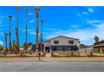 Charming two-story home boasting desert landscaping, a dark blue accent wall, and tall palm trees at 2685 S Tenaya Way, Las Vegas, NV 89117