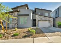 Contemporary home featuring stone accents, a two-car garage, and desert landscaping at 270 Shaded Canyon Dr, Henderson, NV 89012