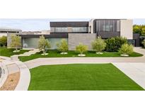 Stunning modern home featuring a pristine lawn, concrete driveway, and minimalist landscaping at 2787 La Bella Ct, Henderson, NV 89052