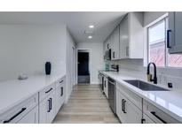 Modern kitchen boasts sleek white cabinetry, stainless steel appliances, and updated fixtures at 5800 Balzar Ave, Las Vegas, NV 89108