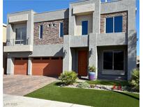 Contemporary home with modern gray stucco, stacked stone accents and an orange front door at 5976 Rockway Glen Ave, Las Vegas, NV 89141