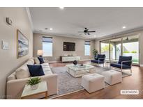 Spacious living room with a plush sofa, accent chairs, and natural light creating an inviting atmosphere at 8393 Canyon Crevasse St, Las Vegas, NV 89166