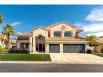 Two-story home featuring a three-car garage, tiled roof, and well-manicured lawn at 8816 Saint Pierre Dr, Las Vegas, NV 89134