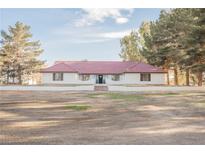 Single-story home featuring a red tile roof, white exterior, and desert landscaping at 1917 N Moapa Valley Blvd, Logandale, NV 89021