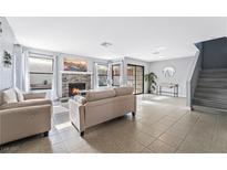 Bright living room features a stone fireplace, large windows and sliding glass doors at 2039 Waverly Cir, Henderson, NV 89014