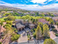 Expansive two-story home with tile roof, two-car garage, mature trees, and landscaping in picturesque, upscale community at 5 Via Ravenna Ct, Henderson, NV 89011
