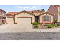 Charming single-story home with a tile roof, three-car garage, and desert landscaping at 820 Wintersweet Rd, Henderson, NV 89015