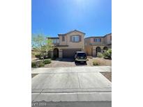 Inviting two-story home featuring desert landscaping, a brick driveway, and a two-car garage at 2409 W Gilmore Ave, North Las Vegas, NV 89032