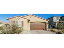 Tan single-story home with a brown two-car garage, landscaped yard, and neutral color palette at 6856 Council Heights Way, Las Vegas, NV 89142
