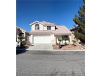 Charming two-story home featuring a two-car garage and well-maintained landscaping with small palm trees at 10404 Mountain Lodge Pl, Las Vegas, NV 89144