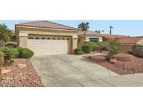 Inviting single-story home with a two-car garage, complemented by desert landscaping and a tiled roof at 10800 Brinkwood Ave, Las Vegas, NV 89134