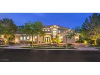Beautifully landscaped two-story home with a well-manicured lawn and driveway at dusk at 1377 Ruby Sky Ct, Henderson, NV 89052
