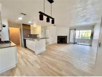 Bright open-concept living room with sleek fireplace and sliding glass doors to balcony at 2200 S Fort Apache Rd # 2123, Las Vegas, NV 89117