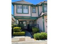 Charming two-story townhouse with pink exterior, green trim, a landscaped front yard, and a welcoming front porch at 4037 Chalfont Ct, Las Vegas, NV 89121