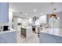 Bright, modern kitchen features white cabinetry, stainless steel appliances, and a large island at 4211 Saxton Green Ave, Las Vegas, NV 89141
