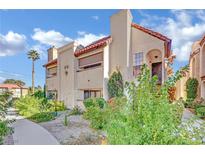 Charming condo featuring stucco walls, a red tile roof and lush landscaping enhancing curb appeal at 1751 E Reno Ave # 203, Las Vegas, NV 89119