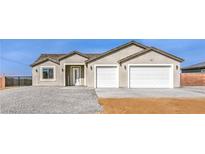 Charming single-story home featuring a two-car garage, gravel landscaping, and stucco siding at 3120 S Torrey Pines Ave, Pahrump, NV 89048