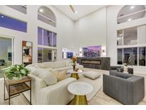 Bright living room boasts soaring ceilings, large windows, and a modern fireplace at 62 Incline Village Ct, Henderson, NV 89074