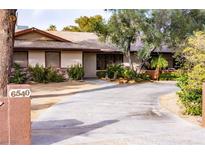 Charming single-story home with mature trees, desert landscaping, and long concrete driveway at 6540 Tara Ave, Las Vegas, NV 89146