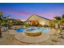 Outdoor pool and hot tub with desert landscaping, covered patio and dusk sky at 6617 Golden Bit Ave, Las Vegas, NV 89131