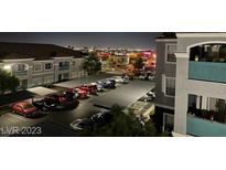 Night view of well lit parking lot with covered parking at residential building near city lights at 6955 Durango Dr # 3092, Las Vegas, NV 89149