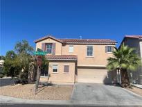 Two story home with a two car garage, desert landscaping, and a red tile roof on a clear day at 8089 Windmill Villa St, Las Vegas, NV 89139