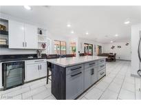 Modern kitchen with a central island, white cabinets, and stainless steel wine cooler at 9005 Feather River Ct, Las Vegas, NV 89117